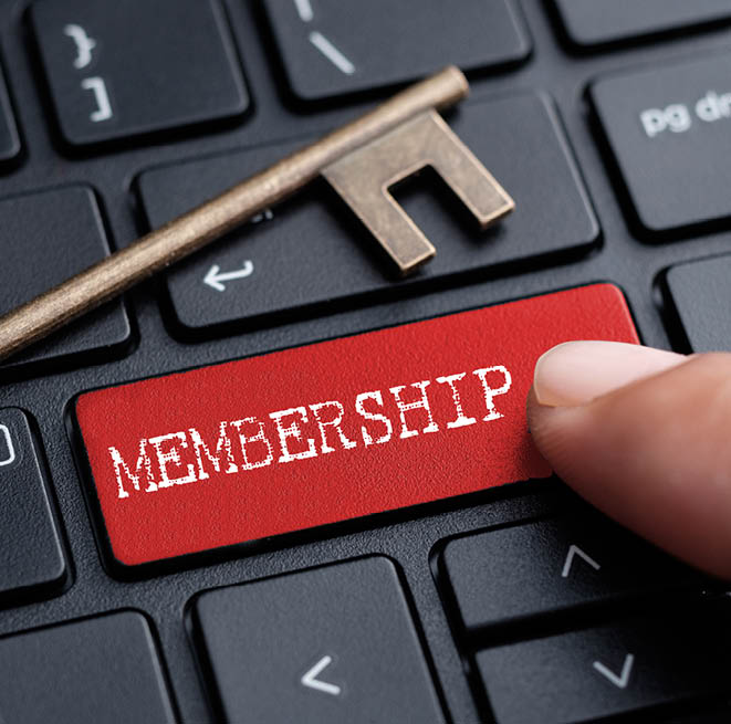 A person is pressing a red button on a keyboard with a key labeled “Membership." Description generated by AI
